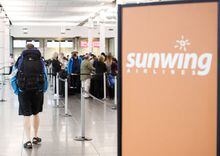 Travellers wait in line at a Sunwing Airlines check-in desk at Trudeau Airport in Montreal, Wednesday, April 20, 2022. Sunwing airlines has reduced its flight schedules from three airports in New Brunswick and Nova Scotia. THE CANADIAN PRESS/Graham Hughes