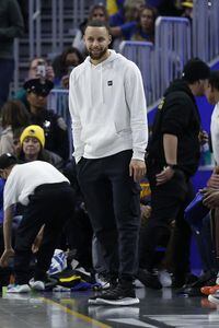 Golden State Warriors guard Stephen Curry, center, stands on the sideline during the second half of an NBA basketball game against the Washington Wizards in San Francisco, Monday, Feb. 13, 2023. (AP Photo/Jed Jacobsohn)