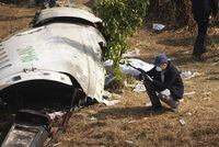 A French investigator takes a photo of the wreckage of a passenger plane at the crash site, in Pokhara, Nepal, Wednesday, Jan.18, 2023. Nepalese authorities are returning to families the bodies of plane crash victims and are sending the aircraft's data recorder to France for analysis as they try to determine what caused the country's deadliest air accident in 30 years. The flight plummeted into a gorge on Sunday while on approach to the newly opened Pokhara International Airport in the foothills of the Himalayas, killing all 72 aboard.(AP Photo/Yunish Gurung)