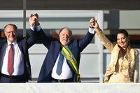 Brazil's new President Luiz Inacio Lula da Silva (C), his wife First Lady Rosangela "Janja" da Silva and new Vice-President Geraldo Alckmin raise their arms at Planalto Palace after their inauguration ceremony at the National Congress, in Brasilia, on January 1, 2023. - Lula da Silva, a 77-year-old leftist who already served as president of Brazil from 2003 to 2010, takes office for the third time with a grand inauguration in Brasilia. (Photo by EVARISTO SA / AFP) (Photo by EVARISTO SA/AFP via Getty Images)