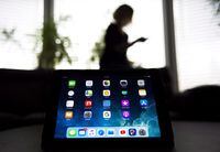 A girl uses her smart phone as apps are shown on an iPad in Mississauga, Ont., on November 13, 2017. A Montreal study suggests that spending too much time on social media or watching television is linked to symptoms of depression among teens. THE CANADIAN PRESS/Nathan Denette