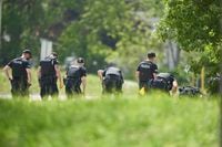 A line of police officers look for evidence at the scene of a car crash in London, Ont., Monday, June 7, 2021. The National Council of Canadian Muslims says it is “beyond horrified” by the vehicle attack, which killed four members of a family in London, Ont., Sunday. THE CANADIAN PRESS/Geoff Robins