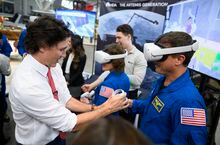 Prime Minister Justin Trudeau helps NASA astronaut Reid Wiseman get set up with a VR headset demonstrating a virtual environment of the Gateway lunar orbit space station, as he meets with the crew of Artemis II at the Canada Aviation and Space Museum in Ottawa, on Tuesday, April 25, 2023. THE CANADIAN PRESS/Justin Tang