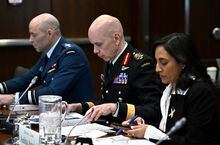 Gen. Wayne Eyre, Chief of the Defence Staff, looks at his notes as he prepares to appear as a witness at the Standing Committee on National Defence, regarding the surveillance balloon from the People's Republic of China, along with Minister of National Defence Anita Anand, right, in Ottawa, on Tuesday, March 7, 2023. THE CANADIAN PRESS/Justin Tang