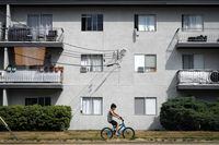 Window mounted air conditioners and exhaust hoses from portable units are seen in apartment windows, in Burnaby, B.C., on Saturday, August 5, 2023. THE CANADIAN PRESS/Darryl Dyck