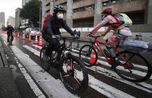 FILE - Commuters wearing protective masks ride their bicycles in Bogota, Colombia, Monday, March 16, 2020. By some measures, over 9% of trips in the capital are by bicycle, putting it in the top tier globally and a model that other cities in Latin America are trying to emulate. (AP Photo/Fernando Vergara, File)