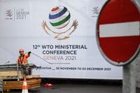 A worker removes fences next to the entrance of the World Trade Organization (WTO) headquarters on November 27, 2021 in Geneva after next week's WTO ministerial conference, the global trade body's biggest gathering in four years, was postponed at the last minute due to the new Omicron Covid-19 variant. (Photo by Fabrice COFFRINI / AFP) (Photo by FABRICE COFFRINI/AFP via Getty Images)