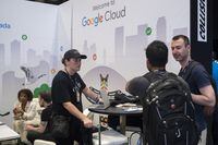 People attending Collision 2022 at the Enercare Centre, chat inside the Google Cloud booth, Toronto June 22, 2022. The event is the largest international in-person gathering in Toronto in more than two years.