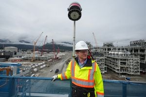 LNG Canada CEO Jason Klein stands on a receiving platform overlooking LNG processing units called trains, right, that are used to convert natural gas into liquefied natural gas at the LNG Canada export terminal under construction, in Kitimat, B.C., on Wednesday, September 28, 2022. THE CANADIAN PRESS/Darryl Dyck