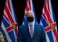 B.C. Premier John Horgan wears a protective face mask to help prevent the spread of COVID-19 prior to being sworn in by The Honourable Janet Austin, Lieutenant Governor of British Columbia during a virtual swearing in ceremony in Victoria, Thursday, November 26, 2020. THE CANADIAN PRESS/Jonathan Hayward
