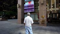 File photo of a man watching the Toronto stock market activity on a screen posted at 121 King Street in Toronto's financial district.