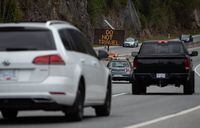 A digital sign with the message "Do Not Travel" sits on the median as motorists travel on the Sea-to-Sky highway between Horseshoe Bay and Lions Bay, B.C., on Friday, April 23, 2021. Non-essential travel is being restricted between three regional zones in British Columbia to try and curb the spread of COVID-19. THE CANADIAN PRESS/Darryl Dyck
