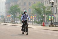 A cyclist wears a mask due to poor air quality conditions as smoke from wildfires in Ontario and Quebec hangs over Ottawa on Tuesday, June 6, 2023. The death of a nine-year-old B.C. boy whose asthma was exacerbated by wildfire smoke is a horrific example of how dangerous poor air quality can be for people suffering from underlying respiratory and cardiac conditions, experts say. THE CANADIAN PRESS/Sean Kilpatrick