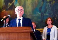 FILE - In this June 20, 2019, file photo, Wisconsin Gov. Tony Evers, surrounded by Democratic lawmakers and members of his Cabinet at a Capitol news conference, is urging Republicans who control the Legislature to pass a state budget that includes Medicaid expansion and more money for schools, in Madison, Wis. Wisconsin's conservative-controlled Supreme Court on Friday, June 21, 2019, upheld lame-duck laws limiting the powers of Democratic Gov. Evers and Attorney General Josh Kaul, handing Republican lawmakers a resounding victory. (AP Photo/Scott Bauer, File)