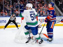 Vancouver Canucks forward Bo Horvat, left, celebrates his goal as Edmonton Oilers forward Ryan Nugent-Hopkins reacts during third period NHL hockey action in Edmonton, Friday, Dec. 23, 2022.THE CANADIAN PRESS/Jeff McIntosh