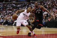 Wizards guard Bradley Beal dribbles the ball as Raptors forward Serge Ibaka defends on Friday.