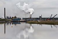 An oil sands extraction facility is reflected in a tailings pond near the city of Fort McMurray, Alberta on June 1, 2014.