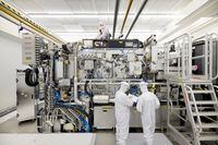 FILE PHOTO: Employees are seen working on the final assembly of ASML's TWINSCAN NXE:3400B semiconductor lithography tool with its panels removed, in Veldhoven, Netherlands, in this picture taken April 4, 2019. Bart van Overbeeke Fotografie/ASML/Handout via REUTERS