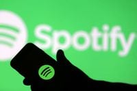 FILE PHOTO: A smartphone is seen in front of a screen projection of Spotify logo, in this picture illustration taken April 1, 2018. REUTERS/Dado Ruvic/Illustration