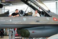 Ukrainian President Volodymyr Zelensky (L) and Danish Prime Minister Mette Frederiksen (R) react as they sit in a F-16 fighter jet in the hangar of the Skrydstrup Airbase in Vojens, northern Denmark, on August 20, 2023. Washington has told Denmark and the Netherlands that they will be permitted to hand over their F-16 fighter jets to Ukraine when the country's pilots are trained to operate them, the US State Department said on August 18, 2023. Both Denmark and the Netherlands are leading the program to train Ukraine's pilots on the F-16. (Photo by Mads Claus Rasmussen / Ritzau Scanpix / AFP) / Denmark OUT (Photo by MADS CLAUS RASMUSSEN/Ritzau Scanpix/AFP via Getty Images)