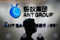 FILE - In this Friday, Oct. 23, 2020, photo, an employee walks past a logo of the Ant Group at their office in Hong Kong. 
Chinese regulatory authorities are fining Ant Group 7.123 billion yuan ($984 million), claiming the financial technology provider violated laws related to corporate governance and consumer rights. The People's Bank of China imposed the fine on Friday, July 7, 2023.  (AP Photo/Kin Cheung, File)