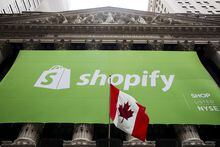 FILE PHOTO: The logo of Shopify hangs behind the Canadian flag after the company's IPO at the New York Stock Exchange May 21, 2015.  REUTERS/Lucas Jackson/File Photo