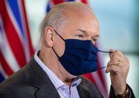 B.C. Premier-elect John Horgan removes his face mask as he prepares to speak during a post-election news conference, in Vancouver, on Sunday, October 25, 2020. THE CANADIAN PRESS/Darryl Dyck