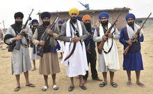 Sikh separatist leader and head of Waris Punjab De, or Punjab's Heirs, Amritpal Singh, canter in yellow turban, stands outside a house with his supporters in the village Jallupur Khera, near Amritsar, India, Saturday, Jan.7, 2023. Indian police on Sunday April 23, arrested, Amritpal Singh, a Sikh separatist leader who has revived calls for secession of India's northern Punjab state bordering a hostile Pakistan, the police said. (AP Photo/Prabhjot Gill)