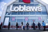 People wait in a line to receive a COVID-19 vaccine at a Loblaws grocery store pharmacy in Ottawa, on Monday, April 26, 2021. Loblaw Companies Ltd. raised its quarterly dividend as it reported its first-quarter profit rose nearly 40 per cent compared with a year ago. THE CANADIAN PRESS/Justin Tang