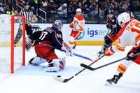 Jan 26, 2022; Columbus, Ohio, USA;  Columbus Blue Jackets goaltender Elvis Merzlikins (90) defends the net as Calgary Flames left wing Matthew Tkachuk (right) scores a goal in the third period at Nationwide Arena. Mandatory Credit: Aaron Doster-USA TODAY Sports