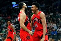 Toronto Raptors' Scottie Barnes (4) reacts with teammate Fred VanVleet after scoring during the second half of an NBA basketball game against the Boston Celtics, Friday, Oct. 22, 2021, in Boston. (AP Photo/Michael Dwyer)