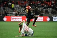 May 11, 2022; Vancouver, British Columbia, Canada;  Valour FC forward William Akio (19) jumps over Vancouver Whitecaps defender Jake Nerwinski (28) during the first half at BC Place. Mandatory Credit: Anne-Marie Sorvin-USA TODAY Sports