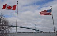 Canadian and American flags fly near the Ambassador Bridge at the Canada/USA border crossing in Windsor, Ont. on Saturday, March 21, 2020. THE CANADIAN PRESS/Rob Gurdebeke