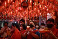 People give offerings and pray at Wat Mangkon temple in Bangkok's Chinatown on the first day of the Lunar New Year.