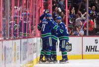 Vancouver Canucks' Zack MacEwan (71) celebrates his second goal with Antoine Roussel, right, of France, and Adam Gaudette, back, during the third period of an NHL hockey game in Vancouver, on Friday, March 6, 2020.