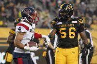 Hamilton Tiger Cats defensive end Ja'Gared Davis will dress Saturday for Hamilton's home game versus the Winnipeg Blue Bombers (10-3). Davis (56) smiles as he shakes hands with Montreal Alouettes defensive back Ciante Evans (4) who just made an interception during first half CFL football game action in Hamilton, Ont. on Friday, June 23, 2023. THE CANADIAN PRESS/Peter Power