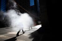 With cool temperatures and bright sun, dedestrians walking on Bay St. in Toronto’s Financial District pass through a blanket of steam rising from a street grate on Temperance St. on Mar 8, 2023. Ontario, (Fred Lum/The Globe and Mail)  