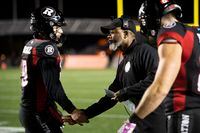 Ottawa Redblacks interim head coach Bob Dyce congratulates quarterback Nick Arbuckle (19) after a touchdown against the Montreal Alouettes during first half CFL football action in Ottawa on Oct. 14, 2022. Shawn Burke will have plenty of options in the CFL draft Tuesday. The Ottawa Redblacks' general manager owns four of the first 17 picks, including the first and 10th selections. THE CANADIAN PRESS/Justin Tang