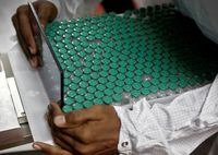 FILE PHOTO: An employee in personal protective equipment (PPE) removes vials of AstraZeneca's COVISHIELD, coronavirus disease (COVID-19) vaccine from a visual inspection machine inside a lab at Serum Institute of India, in Pune, India, November 30, 2020. REUTERS/Francis Mascarenhas/File Photo