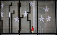A pedestrian wearing a mask walks under Christmas decorations in an empty downtown Calgary, Alta., Wednesday, Dec. 9, 2020, after new provincial restrictions were announced amid a worldwide COVID-19 pandemic. THE CANADIAN PRESS/Jeff McIntosh