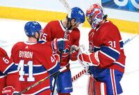 Montreal Canadiens' Jesperi Kotkaniemi, centre, and Paul Byron congratulate goaltender Carey Price for his shut-out victory following third period NHL hockey action against the Edmonton Oilers, in Montreal on Tuesday, March 30, 2021. THE CANADIAN PRESS/Paul Chiasson