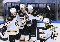 Boston Bruins left wing Jake DeBrusk, third from left, celebrates his goal with teammates Torey Krug, from left, Ondrej Kase and David Krejci as the Bruins beat the Carolina Hurricanes 4-3 on Aug. 17, 2020.
