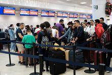Passengers from the Sunwing airlines line up for check in at Cancun International Airport after many flights to Canada have been cancelled because of the severe wintry weather conditions in various parts of the country, in Cancun, Mexico December 26, 2022. REUTERS/Paola Chiomante
