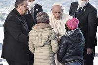 Pope Francis greets two refugee girls at the Reception and Identification Centre (RIC) in Mytilene on the island of Lesbos, Greece, December 5, 2021. Louisa Gouliamaki/Pool via REUTERS