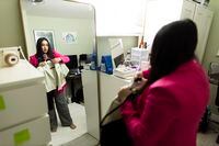 Komal Minhas looks in the mirror while showing some of her office wardrobe at her home in Surrey, British Columbia, Thursday September 8, 2022. Rafal Gerszak/The Globe and Mail 