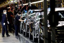 FILE PHOTO: Employees work on the production line during an organised media tour to a factory of Beijing Benz Automotive Co (BBAC), a joint venture by BAIC Motor and Mercedes-Benz, in Beijing, China February 17, 2022. REUTERS/Florence Lo/File Photo