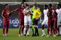 Canada's Alistair Johnston, left, talks to referee Jair Marrufo during a qualifying soccer match against Panama for the FIFA World Cup Qatar 2022 in Panama City, Panama, Wednesday, March 30, 2022. (AP Photo/Arnulfo Franco)