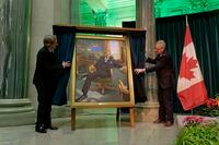 Artist Phil Richards, left, and former Premier Brad Wall, right, unveil Wall’s official portrait at the Legislative Building in Regina on Wednesday, Nov. 30, 2022. THE CANADIAN PRESS/Michael Bell