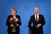 New elected German Chancellor Olaf Scholz, right, and former Chancellor Angela Merkel laughs together during a handover ceremony in the chancellery in Berlin, Wednesday, Dec. 8, 2021. (Photo/Markus Schreiber)