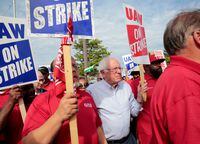 FILE PHOTO: U.S. Senator Senator Bernie Sanders carries a Strike sign with striking United Auto Workers (UAW) in Hamtramck, Michigan, U.S. September 25, 2019.    REUTERS/Rebecca Cook/File Photo